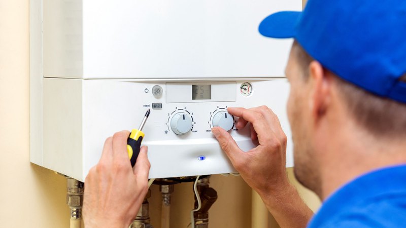 water heater service specialist adjusting settings on a water heater