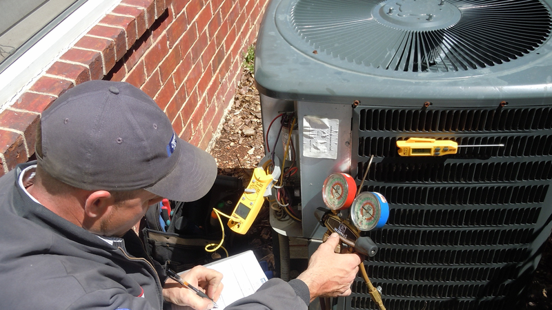 AC repair in progress: a technician is using special tools to check the outside unit. 