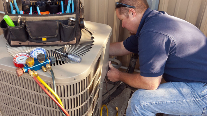 One moment of air conditioning repair process: techician, outside unit, and tools. 