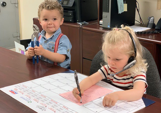 Kids at plumbing repair company office: a girl-receptionist and a boy-technician.