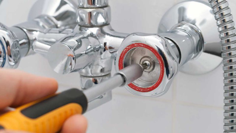 Adjusting a hot-water valve of a bath faucet during shower repair services from our company