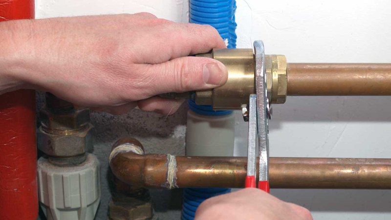 Hands holding a wrench during the heating repair process